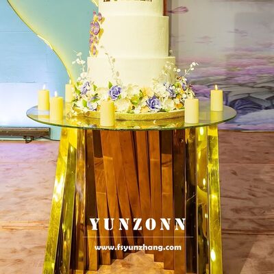 قیمت خوب میز کیک عروسی شیشه ای سفید با پایه قفس طلای گرد از فولاد ضد زنگ برای مبلمان هتل آنلاین